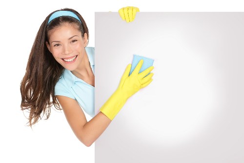 Cleaner tidying a modern Shepherdsbush apartment interior